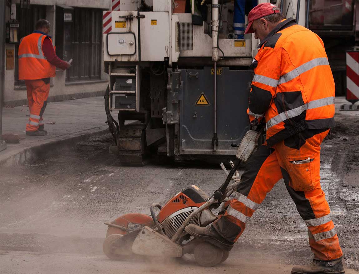 construction worker using concrete cutter